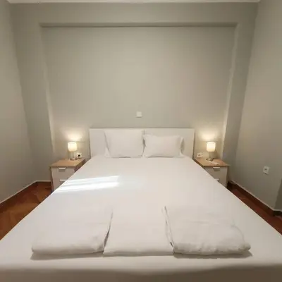 a white bed with two lamps on two tables at Kolonaki Corner -- Bright 2-Bed close to Metro in Athens