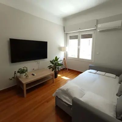 a bedroom with a bed and a flat screen tv at Kolonaki Corner -- Bright 2-Bed close to Metro in Athens