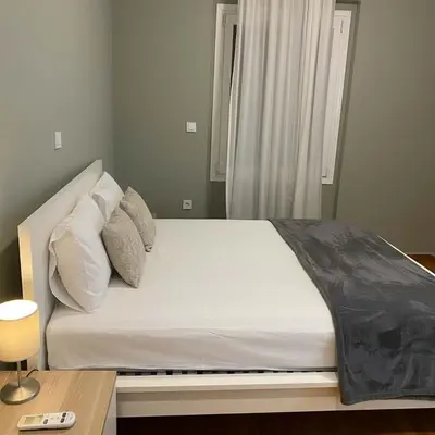 a bed with white sheets and pillows in a bedroom at Kolonaki Corner -- Bright 2-Bed close to Metro in Athens