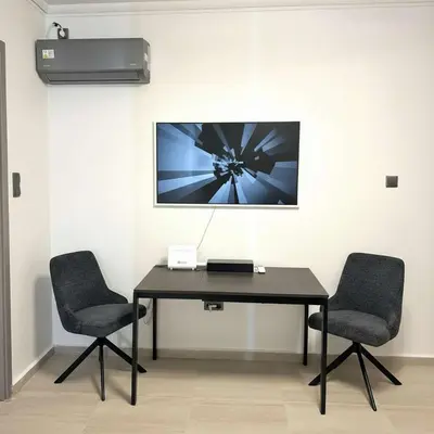 a desk with two chairs and a picture on a wall at The Perch Kolonaki Square Studio Prime Location in Athens