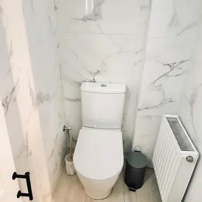 a white bathroom with a toilet and a radiator at The Perch Kolonaki Square Studio Prime Location in Athens