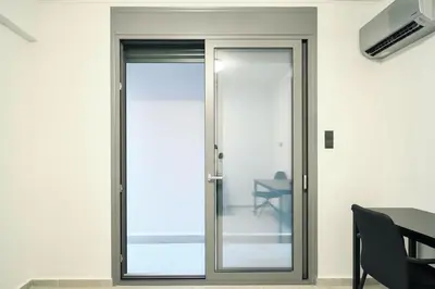 a sliding glass door in a room with a table at The Perch Kolonaki Square Studio Prime Location in Athens