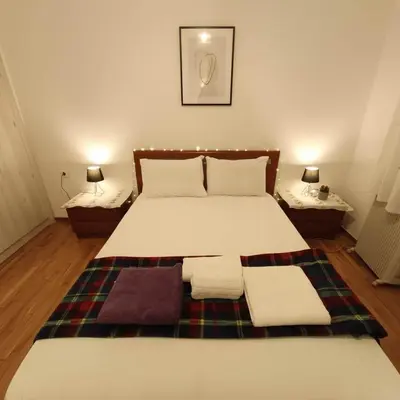 a bedroom with a bed with a blanket and two lamps at Your Cozy Corner in Central Kypseli in Athens
