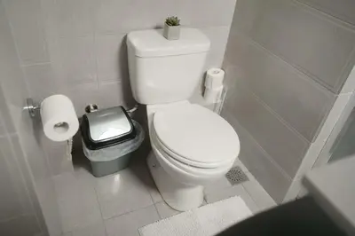 a bathroom with a white toilet and a trash can at Your Cozy Corner in Central Kypseli in Athens