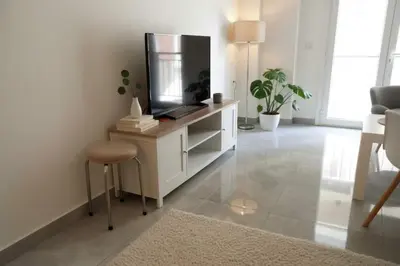 a living room with a tv and a stool at Your Cozy Corner in Central Kypseli in Athens