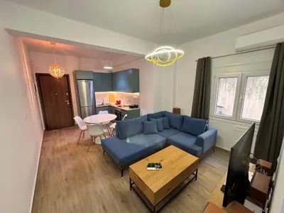 a living room with a blue couch and a table at A&C Urban Elegance in Athens