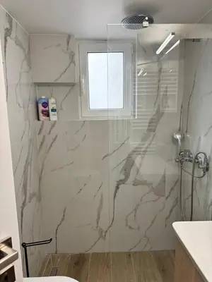 a bathroom with a marble shower with a window at A&C Urban Elegance in Athens