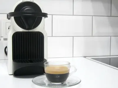 a cup of coffee on a plate next to a coffee maker at Walk to Acropolis of Athens,15-min Metro nearby in Athens