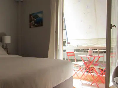 a bedroom with a bed and a balcony with a table and chairs at Walk to Acropolis of Athens,15-min Metro nearby in Athens