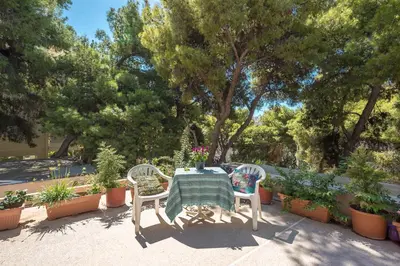 a table and two chairs with a table and some plants at Cozy Loft Vouliagmeni in Athens