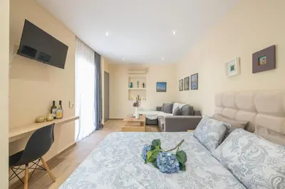 a living room with a bed and a couch at Cozy Loft Vouliagmeni in Athens