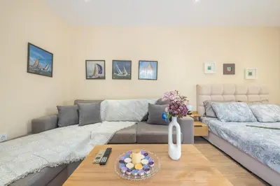 a living room with a couch and a table at Cozy Loft Vouliagmeni in Athens