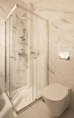 a white bathroom with a shower and a toilet at Elvita Apartments 5 in Athens