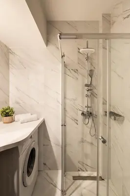 a shower in a bathroom with a washing machine at Elvita Apartments 5 in Athens