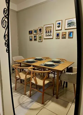 a dining room with a table and chairs and a mirror at Leon Filoxenia in Athens