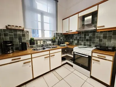 a kitchen with white cabinets and a sink and a window at Leon Filoxenia in Athens