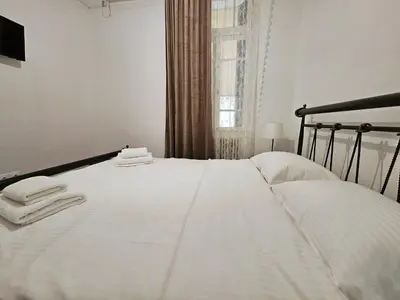 a bedroom with a white bed with towels on it at Leon Filoxenia in Athens