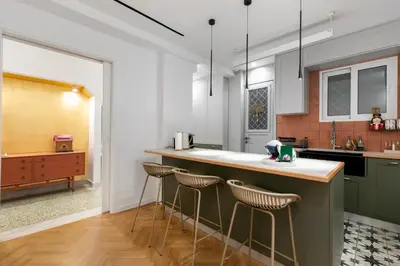 a kitchen with green cabinets and bar stools at Elysia - Crafted 2-Bedroom Apt & Balcony in Athens in Athens
