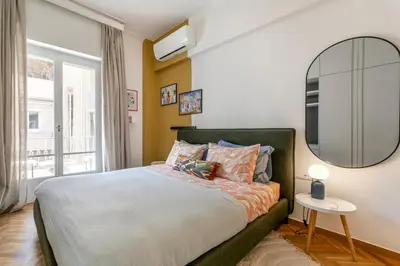 a bedroom with a large bed and a mirror at Elysia - Crafted 2-Bedroom Apt & Balcony in Athens in Athens