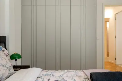a bedroom with white walls and a bed and a green lamp at Elysia - Crafted 2-Bedroom Apt & Balcony in Athens in Athens