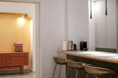 a kitchen with a counter with three stools at Elysia - Crafted 2-Bedroom Apt & Balcony in Athens in Athens