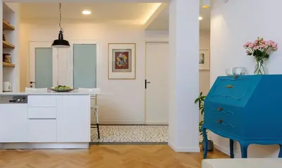 a kitchen with white cabinets and a blue chair at Athens Anasses Luxury Apartments in Athens
