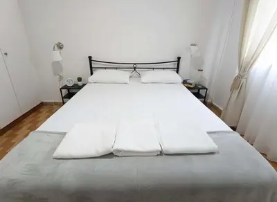 a large white bed with white sheets and pillows at Your Piraeus Escape Cozy One-Bedroom Apartment in Piraeus