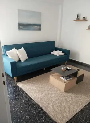 a blue couch in a living room with a coffee table at Your Piraeus Escape Cozy One-Bedroom Apartment in Piraeus