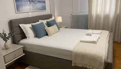 a bedroom with a large bed with blue and white pillows at Athens Central Gem 2-Bedroom Retreat in Athens