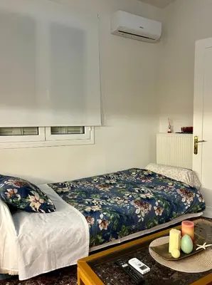 a bedroom with a bed and a table with a tray of fruit at Easy Stay Airport Athens in Koropíon