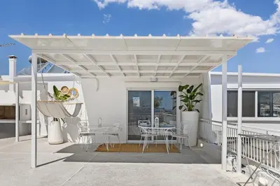 a white pergola on a balcony with a table and chairs at Apt 1' From The Sea With Private Terrace & BBQ in Vari
