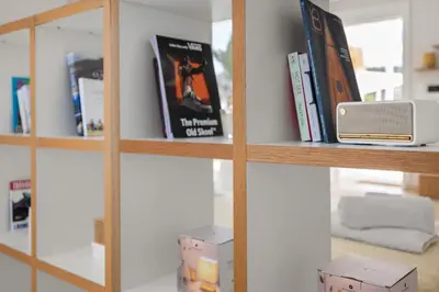 a book shelf with books and a router on it at Apt 1' From The Sea With Private Terrace & BBQ in Vari