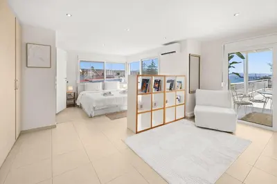 a white bedroom with a bed and a chair at Apt 1' From The Sea With Private Terrace & BBQ in Vari