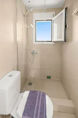 a bathroom with a shower and a toilet and a window at Apt 1' From The Sea With Private Terrace & BBQ in Vari
