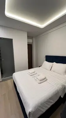 a bedroom with a large white bed with towels on it at ERIFILI -mini apartment in Athens