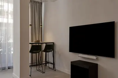 a living room with two stools and a flat screen tv at Charitos Luxury Hideaway 2bd Apt in Kolonaki in Athens