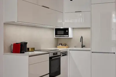 a white kitchen with a stove and a microwave at Charitos Luxury Hideaway 2bd Apt in Kolonaki in Athens