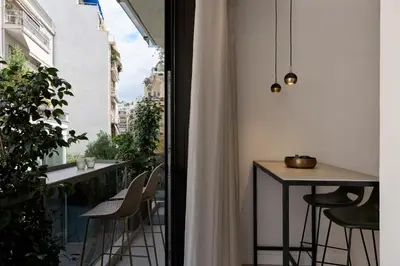 a room with a balcony with a table and chairs at Charitos Luxury Hideaway 2bd Apt in Kolonaki in Athens