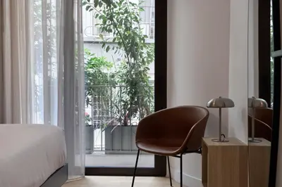 a bedroom with a chair in front of a window at Charitos Luxury Hideaway 2bd Apt in Kolonaki in Athens