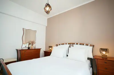 a bedroom with a white bed and a mirror at Comfy stay 2BR flat 1Gbps 4 min walk from metro in Athens