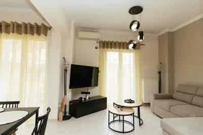 a living room with a couch and a tv at Comfy stay 2BR flat 1Gbps 4 min walk from metro in Athens