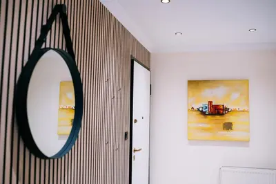 a mirror hanging on a wall next to a hallway at Comfy stay 2BR flat 1Gbps 4 min walk from metro in Athens