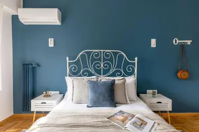 a blue bedroom with a bed with a blue wall at Family-Friendly Thisseio Retreat Near Acropolis in Athens