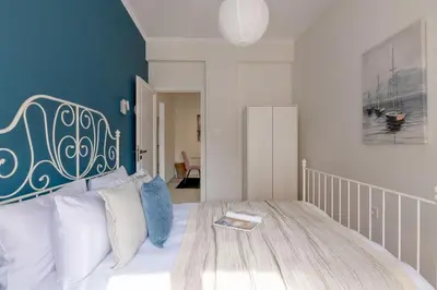 a bedroom with a large bed with a blue wall at Family-Friendly Thisseio Retreat Near Acropolis in Athens