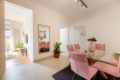 a dining room with a glass table and pink chairs at Family-Friendly Thisseio Retreat Near Acropolis in Athens