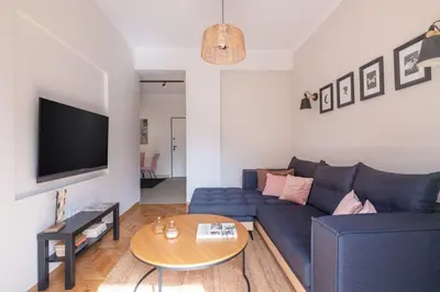 a living room with a blue couch and a table at Family-Friendly Thisseio Retreat Near Acropolis in Athens