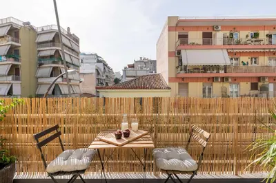 a table and chairs on a balcony with buildings at Family-Friendly Thisseio Retreat Near Acropolis in Athens