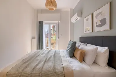 a bedroom with a large white bed with a window at Family-Friendly Thisseio Retreat Near Acropolis in Athens
