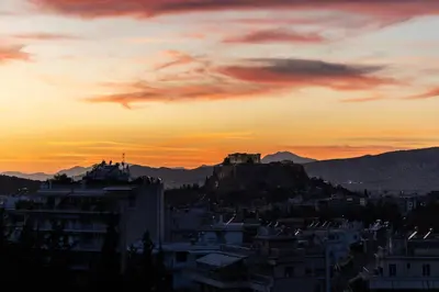 a view of a city at sunset at Urban Forty One Acropolis-view penthouse in Athens