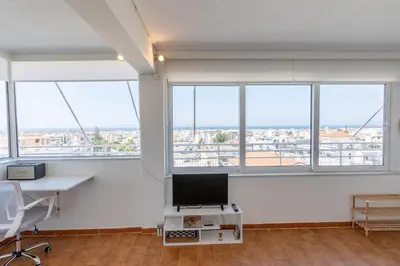 an office with windows and a desk with a computer at Glyfada Residence Top Floor With Sea & Tower View in Athens